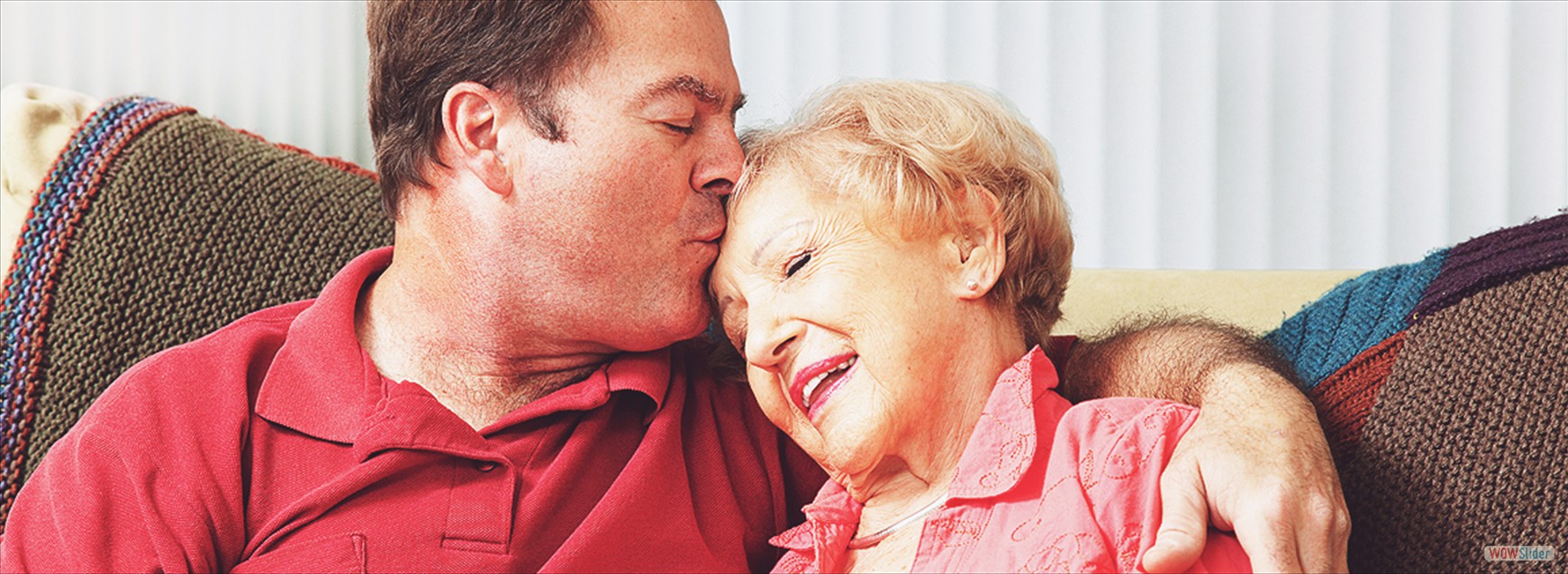 older man kissing older woman on head